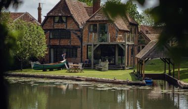 a house with a boat on the water in front of it