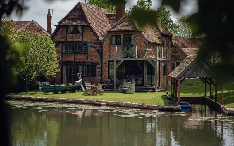 a house with a boat on the water in front of it