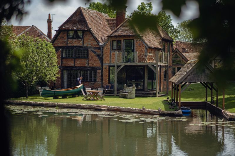 a house with a boat on the water in front of it