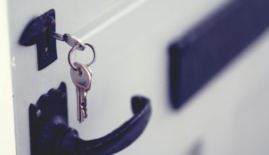 black and silver padlock on white door