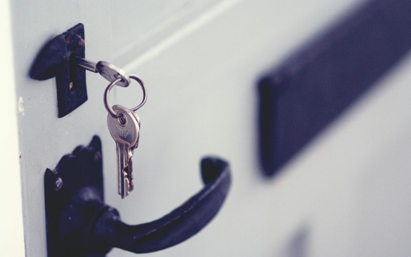 black and silver padlock on white door