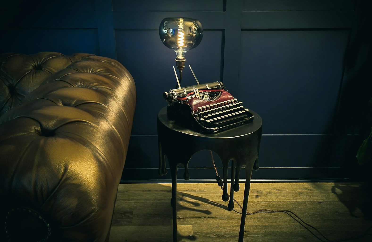 a table with a lamp on top of it next to a couch