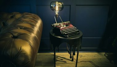 a table with a lamp on top of it next to a couch