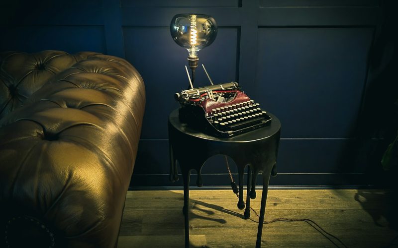 a table with a lamp on top of it next to a couch